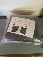 Photo of foam acoustic panels in compressed sealed plastic packaging with instructional paper showing panels expanding to full size after 24-48 hours.
