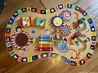 Full top view of the wooden activity table showing all features and alphabet border