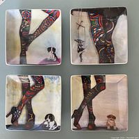 Four square art plates arranged in two rows of two, each depicting colorful patterned legs and small dogs or figures, on a flat surface.
