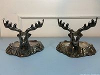 Pair of metal reindeer shaped candle holders/trinket dishes with textured leaf bases.