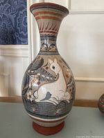 Full view of Tonala vase showing shape, base, neck and painted deer motif with folk art floral elements.