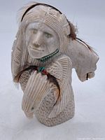 Front view showing human figure and horse head motif with bead and feather accents