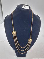 Full view of the antique Art Nouveau style necklace displayed on a velvet bust stand, showing the gold-tone chains and decorative side embellishments.
