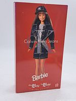 Front view of unopened Barbie box showing doll in denim outfit, red background, Calvin Klein Jeans logo.