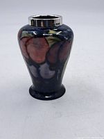 Full view of the Moorcroft ceramic vase with floral glazed pattern and sterling silver lip.