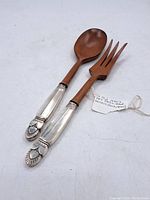 Pair of Art Deco salad servers consisting of a wooden spoon and fork with decorative silver-toned metal ends.