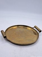 Full overhead image of the vintage brass tray showing ribbed handles and overall shape.