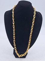 Full-length gold-tone chain necklace displayed on a black bust showing overall design and drape.