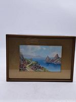 Full view of the framed watercolour painting depicting a coastal maritime scene with cliffs and sea.