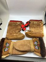 Photo of moccasins and gloves displayed flat on white background showing overall set