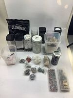 Overview of jars, containers, loose stones, and packs of crafting materials including Jesmonite powder bag and multiple loose raw stones and crystals
