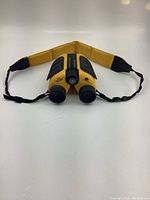 Front view of yellow V-Optics binoculars with carrying strap extended