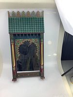 Front view of the Moroccan carved wooden mirror showing the detailed hand-painted architectural design and arched mirror.