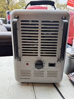 Front view of HeatSafe heater showing ventilation grill, power switch, and temperature control knob with handle on top.
