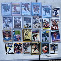 Photo of 25 assorted hockey cards laid out in a grid on a light surface showing different players and card styles