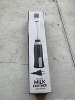 Photo of the boxed electric milk frother showing product image and plug type.