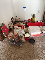 Wide angle photo showing stacked napkins, a poinsettia napkin holder, assorted decor, and brass candlesticks.