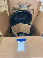 Box opened showing large black speckled canning pot, lid and metal rack inside with cardboard divider