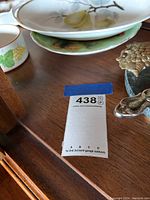 View including the surrounding serving dishes with fruit artwork and a chair