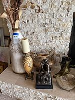 Photo showing the six pieces of home decor including figurines, vases, and candle holder arranged on a shelf