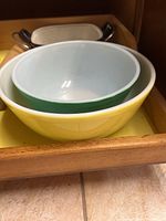 Three nested vintage Pyrex mixing bowls, yellow outside, green mid-size, white inner bowl