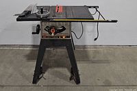 Front view of Craftsman table saw showing blade insert, control knobs, and stand with wheels.