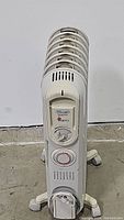 Front view of the Delonghi radiator heater showing the control dials, brand, and model name.