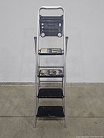 Front view of 5 foot aluminum ladder showing four black steps and top handle.