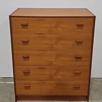 Front view of the dresser showing five drawers with paired square and rectangular wooden handles.