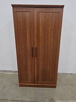 Full front view of oak pantry cabinet showing two doors and handles