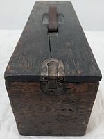 Front view of vintage wooden tool box showing metal clasp and leather handle