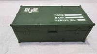 Top view of closed green plastic GI Joe storage case showing logo and labeled fields for Name, Rank, Serial No.