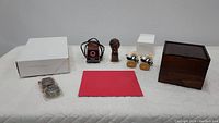 Photo showing the full lot including Abraham Lincoln bust, Schermerhorn bobblehead statues, tape dispensers, wooden box, envelope box, red envelope, and square electronic-like object with wires.