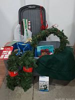 Photo showing Christmas wreath, garlands, tote lid, wrapping paper, gift bags, lights box, and tree skirt.
