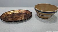 Photo showing both the Bombay hand painted glass platter and Watt McCoy yellowware mixing bowl side by side on a white surface.