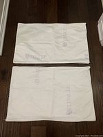 Top view of two white Tencel pillow protectors laying flat, showing TENCEL branding and fabric texture.