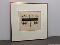 Full view of framed Erte lithograph showing metal frame and double mat surrounding print