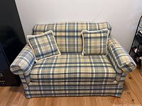 Front view of the plaid upholstered love seat with two matching cushions on seat showing fabric pattern and overall condition.