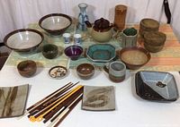 Full view of the sushi inspired lot items including bowls, plates, cups, chopsticks, mats on a flat surface.