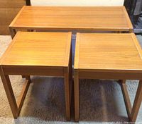 Top front view showing three teak tables grouped together, two square and one rectangular behind