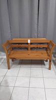 Front view showing the full wooden bench with natural finish and carved backrest.