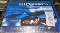 Box front showing product name and images of headlights and car graphics.