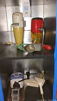 The lot displayed with various kitchen attachments including Rival Coffee Mill and others on metal shelf.