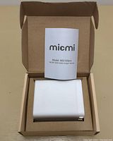 Open box view of white Micmi MG100pro charger with instruction manual visible inside the box.