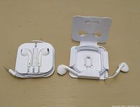 Photo showing two white wired earphones with their cords neatly coiled on packaging card holders. One earphone set has a 3.5mm jack, the other a Lightning connector.