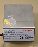 Front view of the Onlyfire rotisserie drive motor showing metal casing and specification label with model RM-A206 and voltage info.