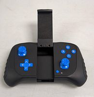 Front view of the black drone controller highlighting blue joysticks, blue D-pad, buttons, and the smartphone mount holder in center.