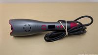 Top view of the grey and pink hair curler, showing digital controls and power button on handle.