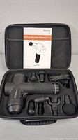 Muscle Stimulator Massage Gun with manual and six interchangeable massage heads inside a black carrying case.