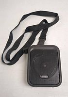 Front view of the SHIDU SD-M100 wireless microphone attached to a black neck strap showing the speaker grille and brand label.